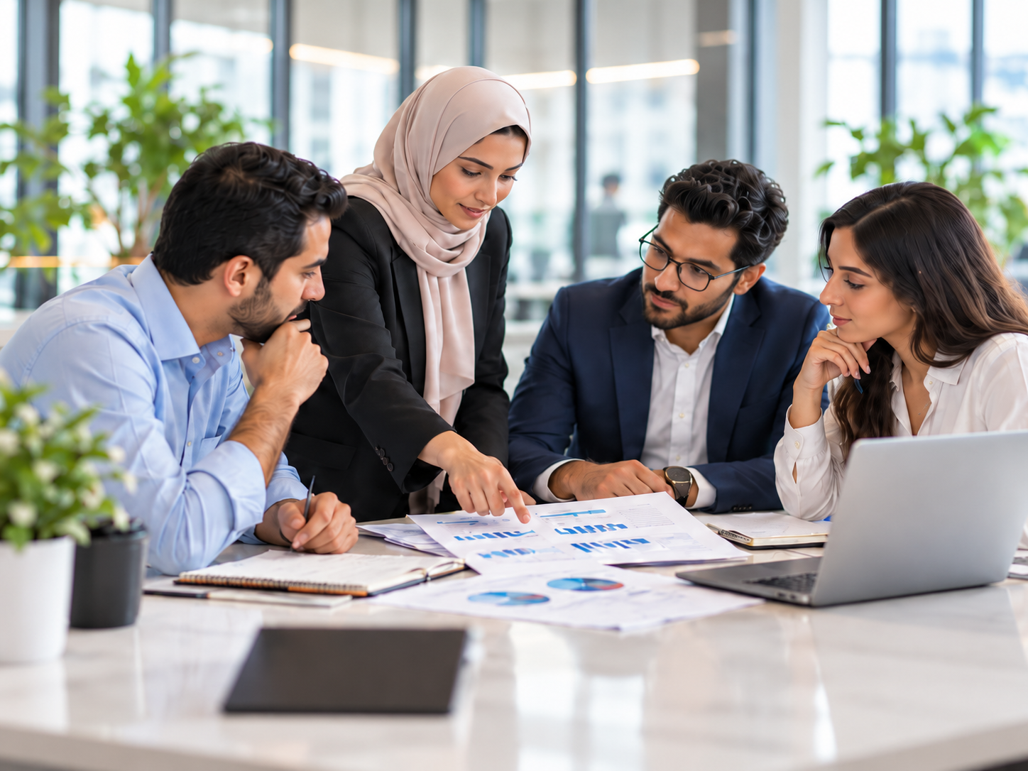 فريق مهني يتعاون في قراءة البيانات وتطوير الأفكار داخل بيئة عمل مشتركة
